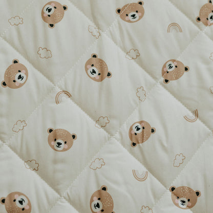 White quilt with teddy bear pattern on a white background