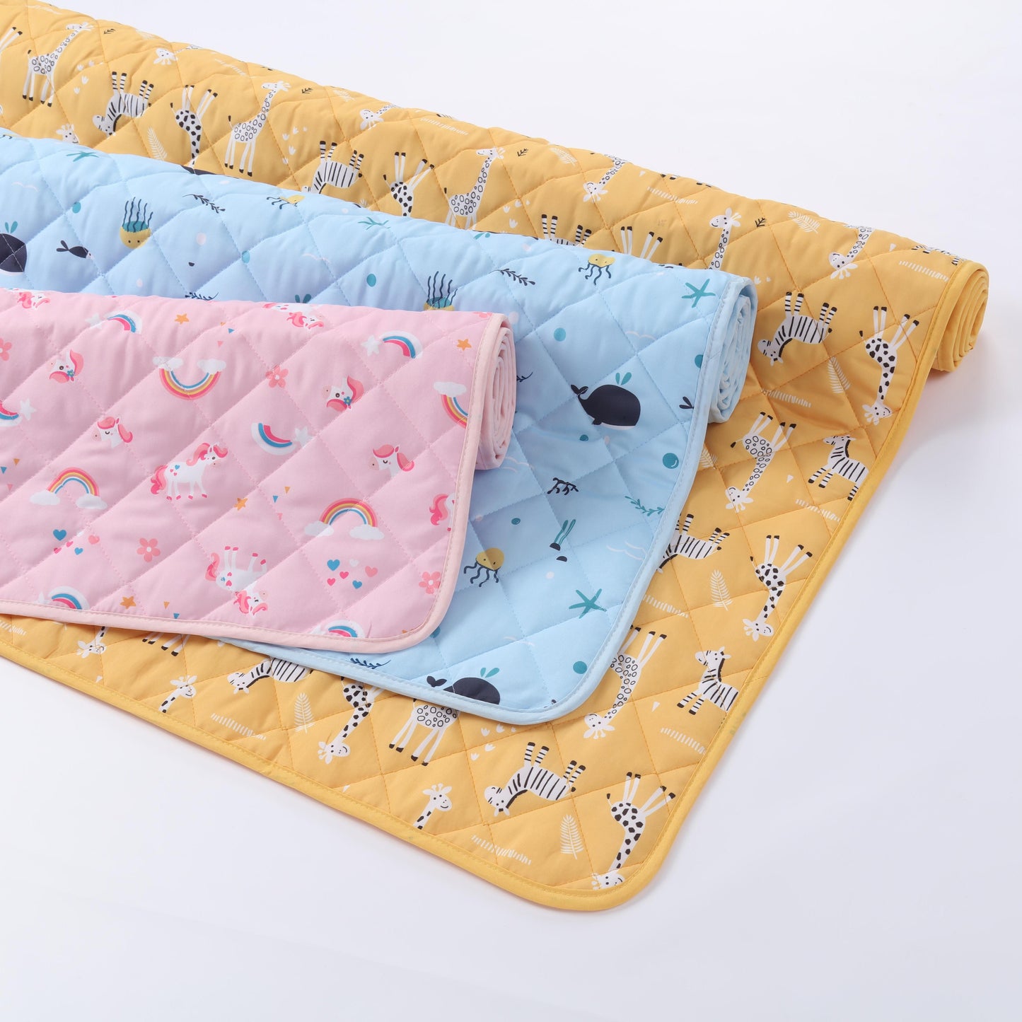 Three quilted baby blankets in yellow, pink, and blue with animal patterns on a white background.