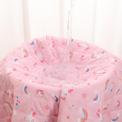 bed wetting blanket with unicorn and rainbow pattern against a white curtain background