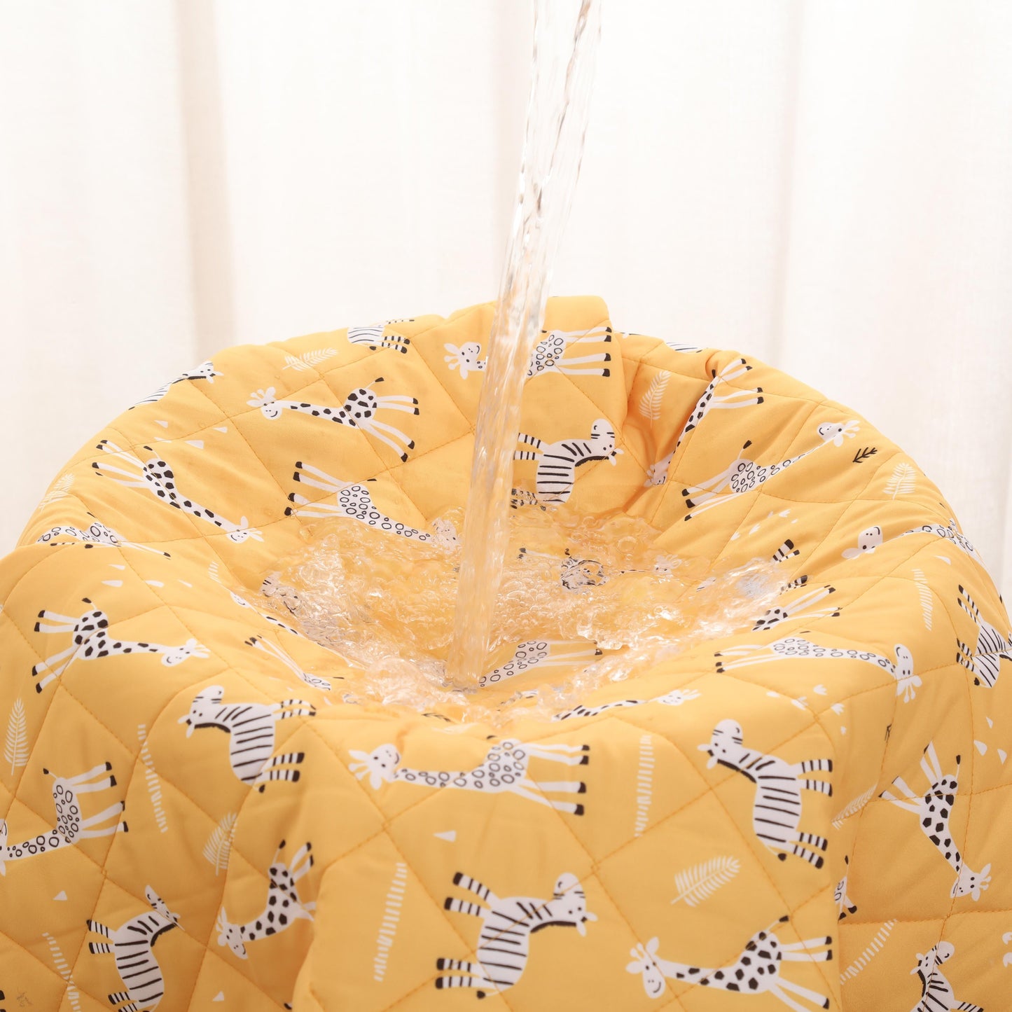 bed wetting blanket with giraffe against a white curtain background